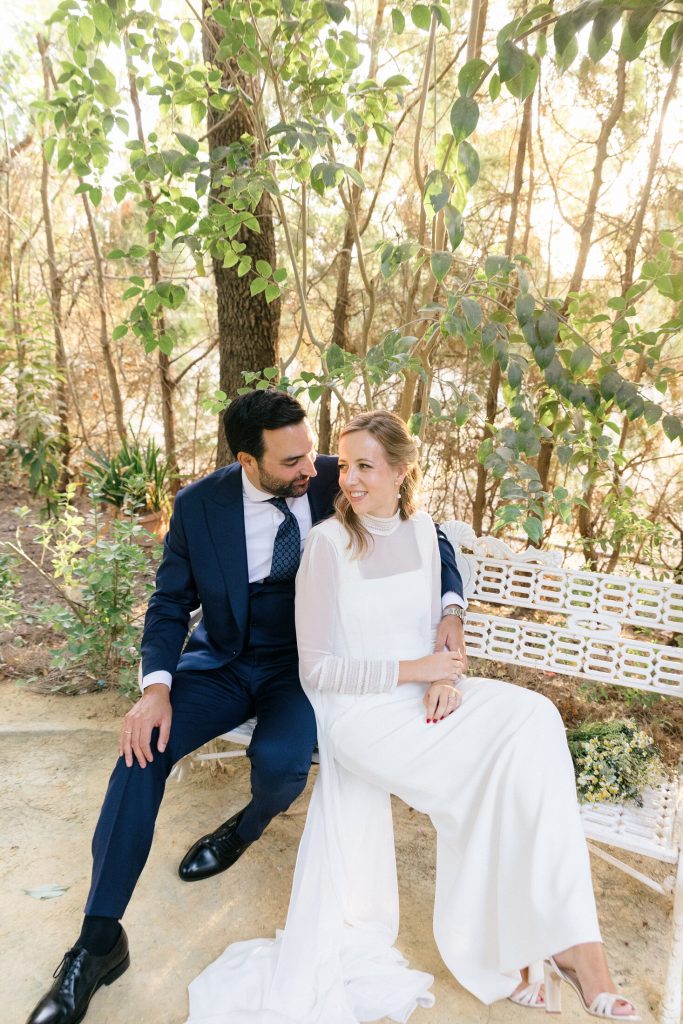 Novios sentados en un banco del jardín