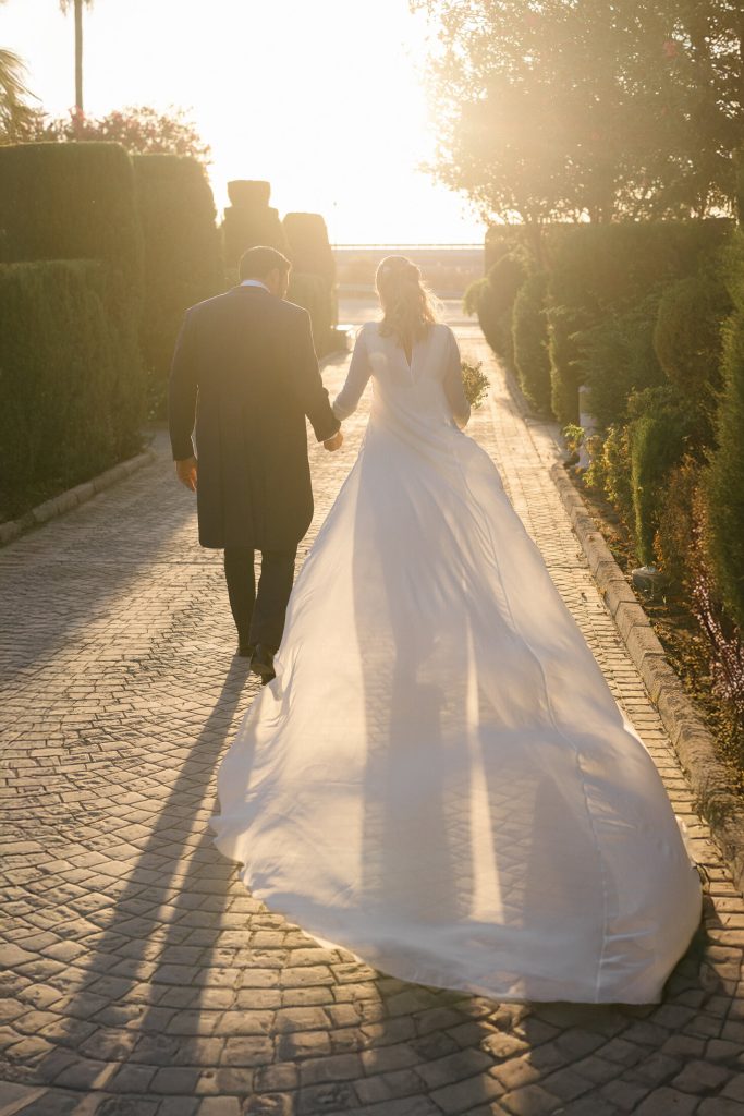 Novios paseando a contraluz durante el atardecer