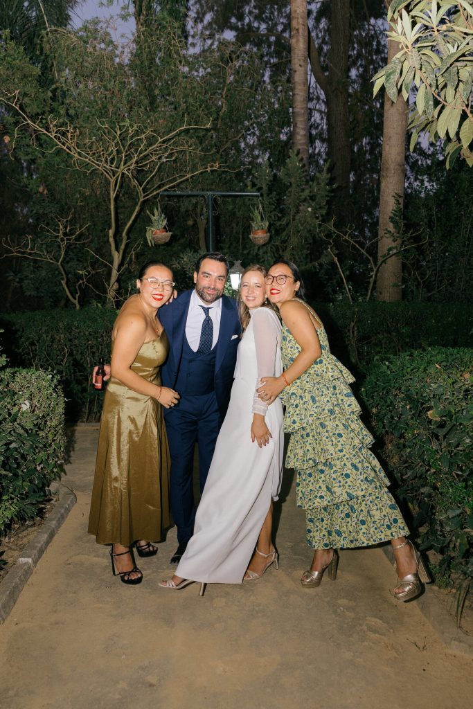 Novios con un grupo de invitados bajo el túnel de luces de la finca