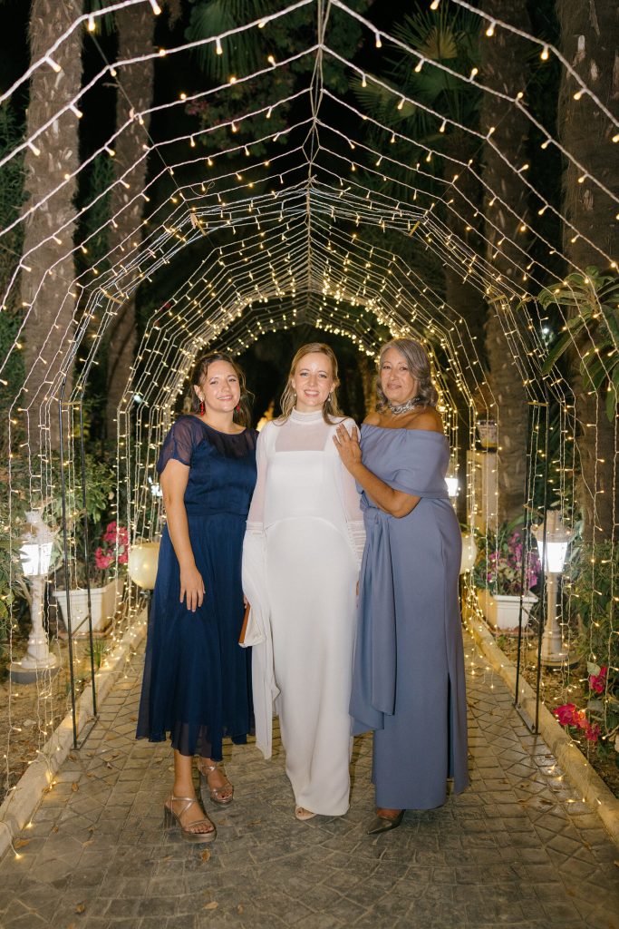 Novios junto a un familiar con un ramo de flores