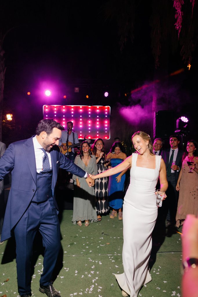 Novios bailando bajo las luces de la fiesta
