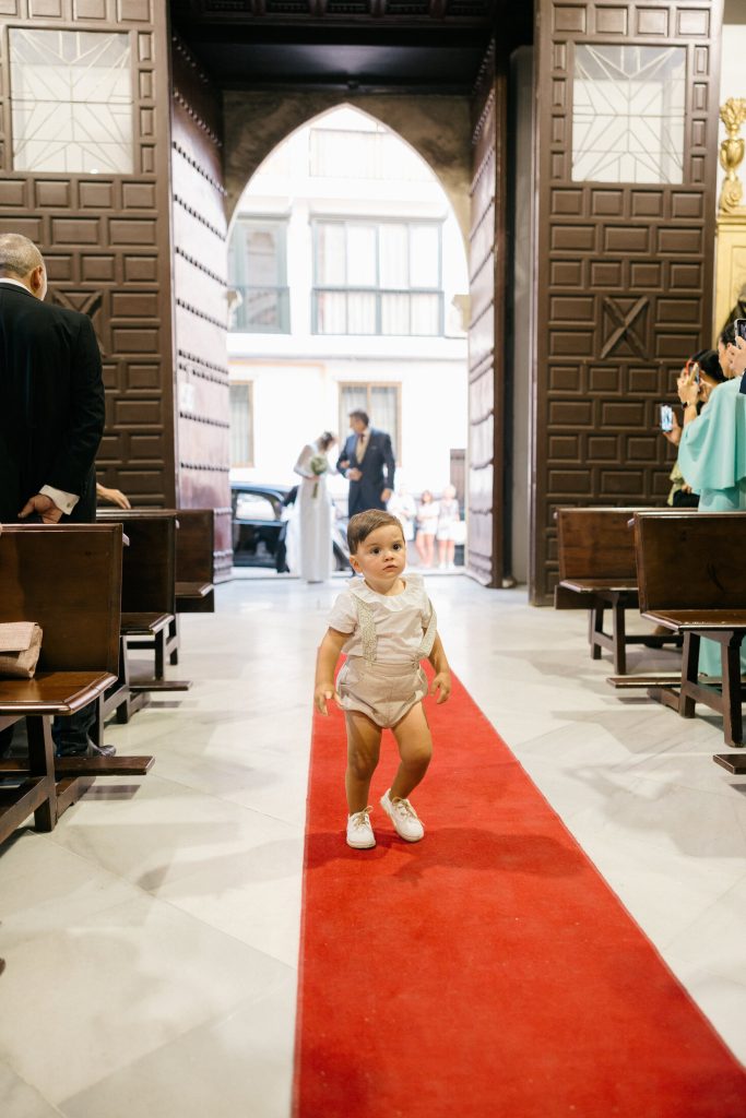 Niño caminando por el pasillo central de la iglesia