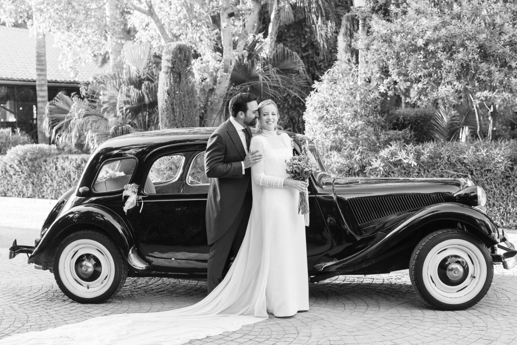 Novios junto a un coche clásico tras la ceremonia