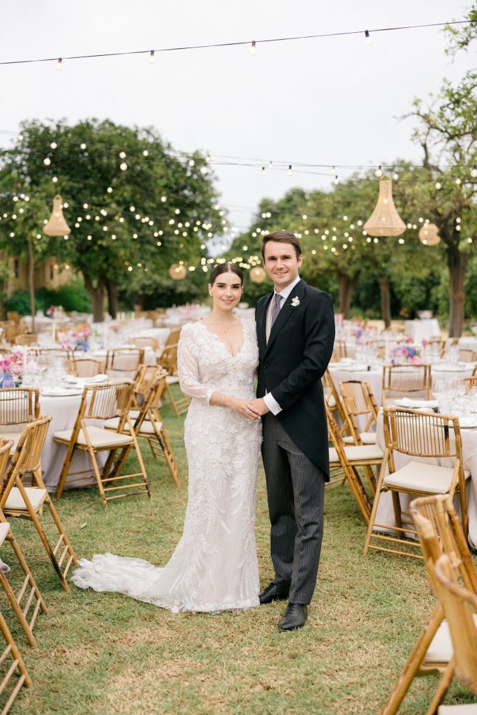 Retrato de los novios al atardecer con guirnaldas de luces