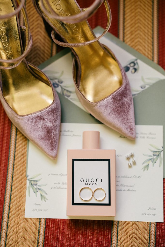 Detalle de los zapatos de novia y el perfume sobre un mantón bordado