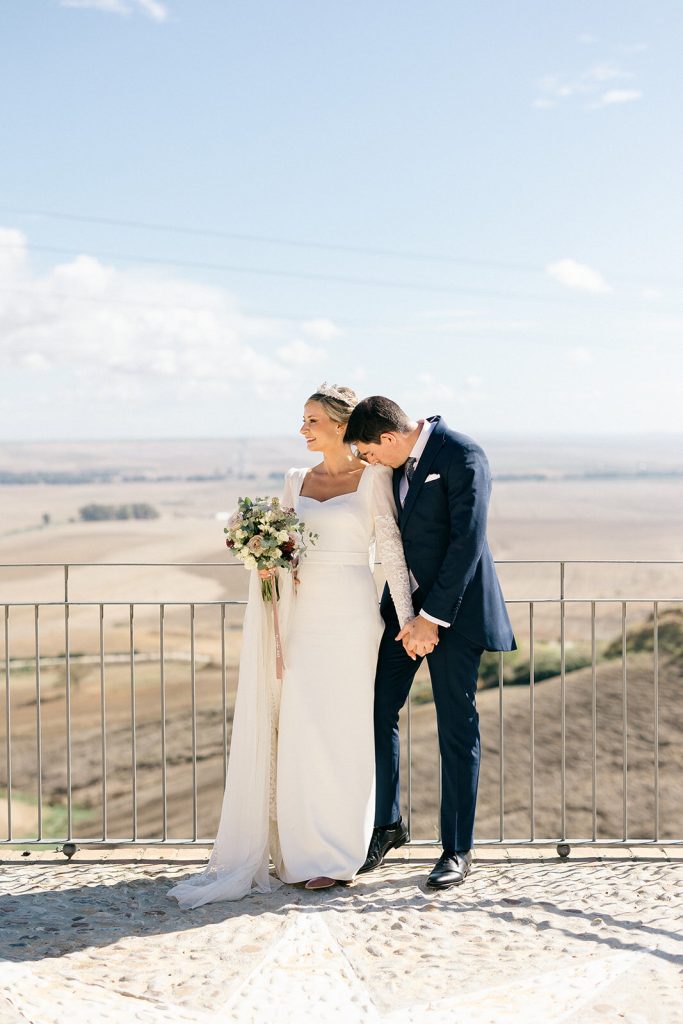 Los novios besándose con el paisaje sevillano de fondo